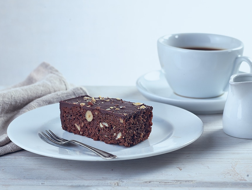 Chocolate and hazelnut slice on a plate with coffee